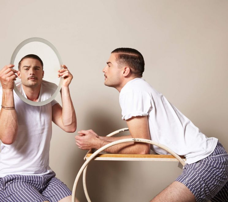 Mężczyzna wpatrzony we własne odbicie w lustrze