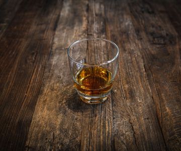 Szklanka alkoholu na drewnianym stole