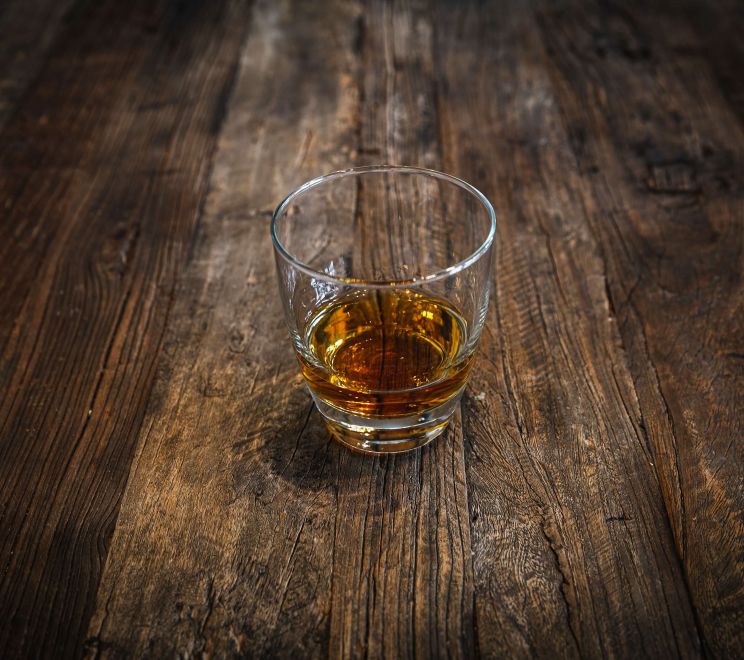Szklanka alkoholu na drewnianym stole